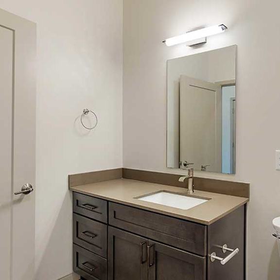 Thumbnail 5 of 33 a bathroom with a quartz vanity sink, mirror, and overhead over lighting