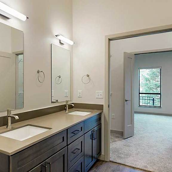 Thumbnail 31 of 33 a bathroom with a double sink, mirror, and overhead lighting fixtures