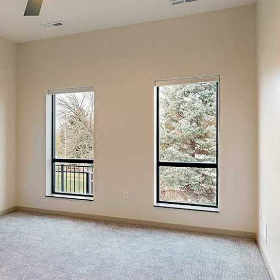 Thumbnail 26 of 33 a bedroom with two windows and a carpeted floor