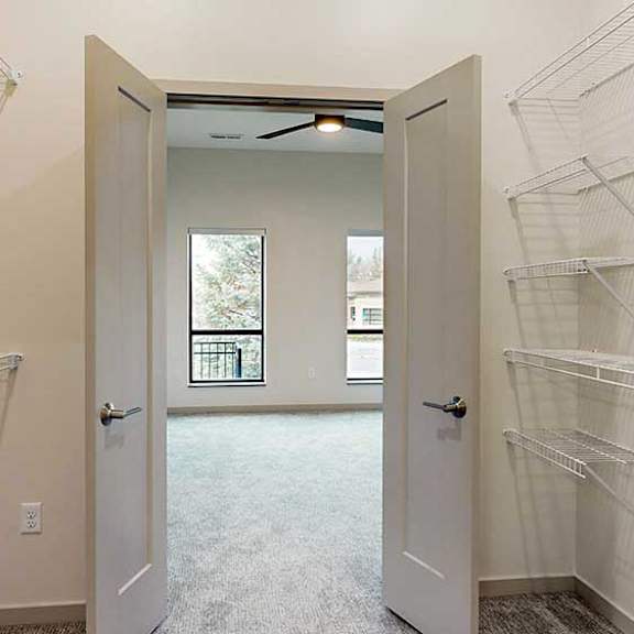 Thumbnail 29 of 33 a walk-through closet with double doors opening into the bedroom