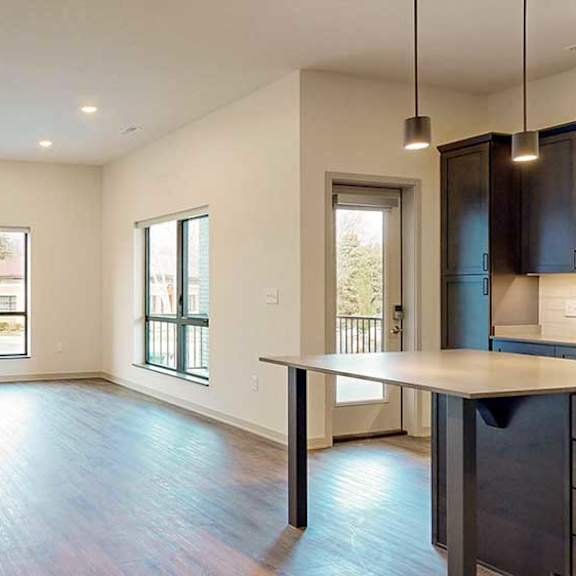 Thumbnail 11 of 33 a spacious living room with hardwood floors and two large windows