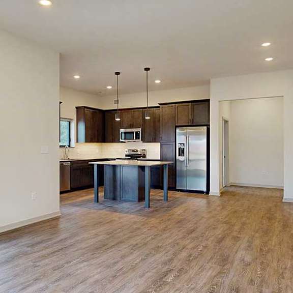 Thumbnail 13 of 33 an open kitchen and living room with hardwood floors and a large window