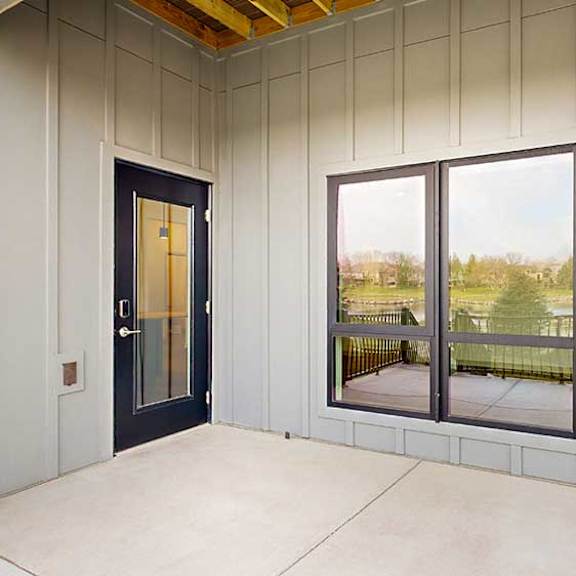 Thumbnail 21 of 33 a walk-out patio with a large window and a black windowed door