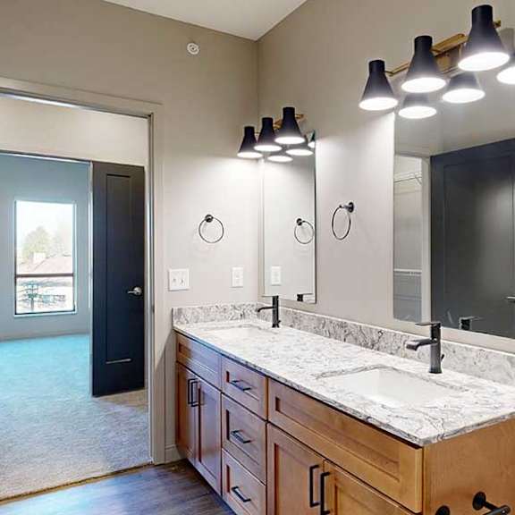 Thumbnail 33 of 33 a bathroom with a double vanity sink, two mirrors, and a door to the walk-through closet