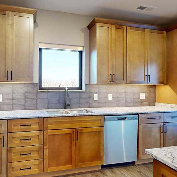 Thumbnail 19 of 33 a kitchen with light brown wooden cabinets and a sink with a window above it