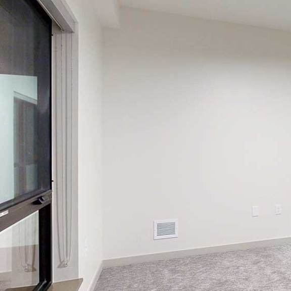 Thumbnail 21 of 25 a bedroom with carpeted flooring, white walls, and a large window
