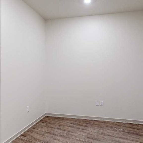 Thumbnail 23 of 25 a den with white walls and hardwood flooring
