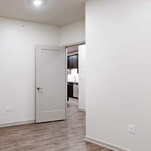Thumbnail 22 of 25 a den with hardwood flooring and a door to the kitchen area
