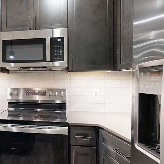 Thumbnail 6 of 25 a modern kitchen with a stainless steel range and microwave