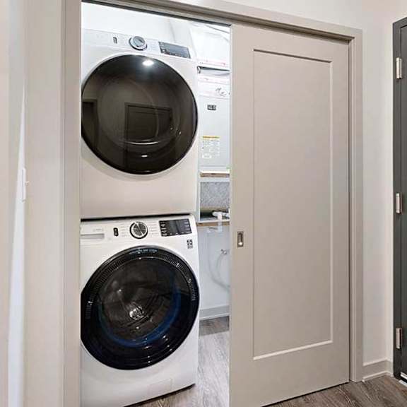 Thumbnail 16 of 25 a stackable washer and dryer in a double door closet