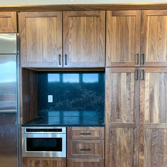 Thumbnail 2 of 26 a luxury modern kitchen with wooden cabinets, a marble backsplash, and a stainless steel refrigerator