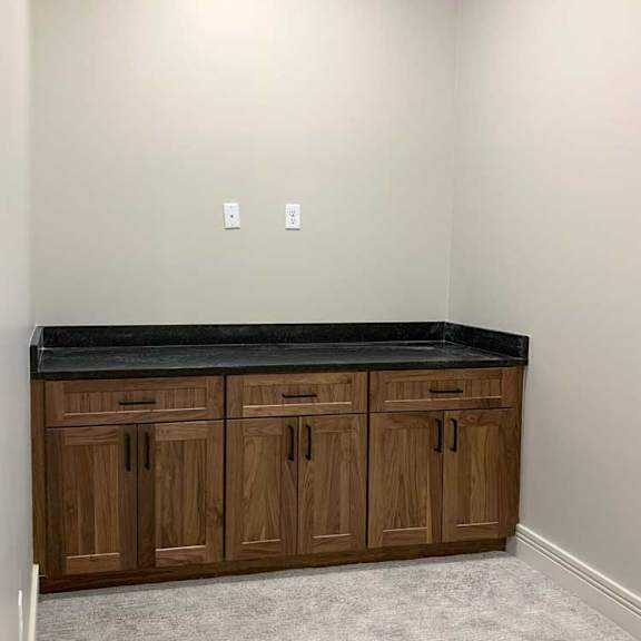 Thumbnail 18 of 26 a carpeted den space with a built-in cabinet with marble countertop