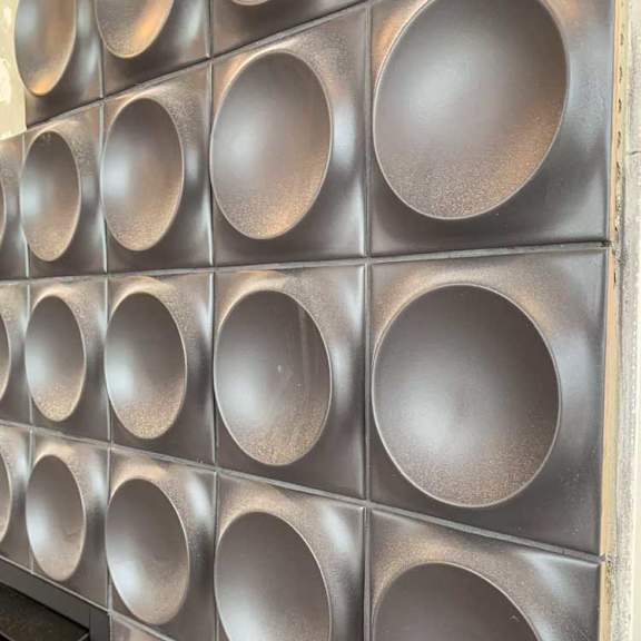 Thumbnail 9 of 26 a fireplace accent wall with a series of circular tiles