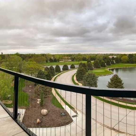Thumbnail 26 of 26 a balcony the neighboring golf course pond and a green landscape