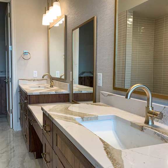 Thumbnail 20 of 26 a bathroom with two marble vanity sinks and three tall mirrors