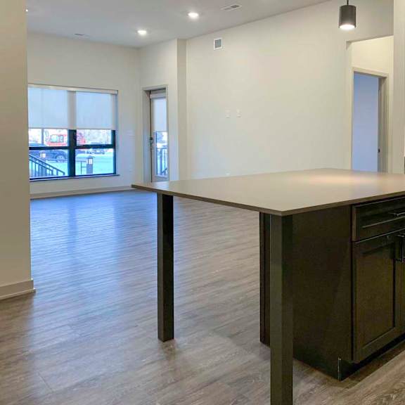 Thumbnail 2 of 29 a kitchen with dark wooden cabinets and a large island with a quartz countertop