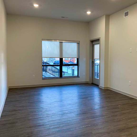 Thumbnail 11 of 29 a living room with wooden flooring and large window with a roller shade