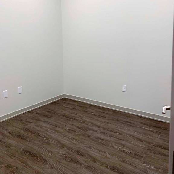 Thumbnail 24 of 29 a den with hardwood floors and white walls