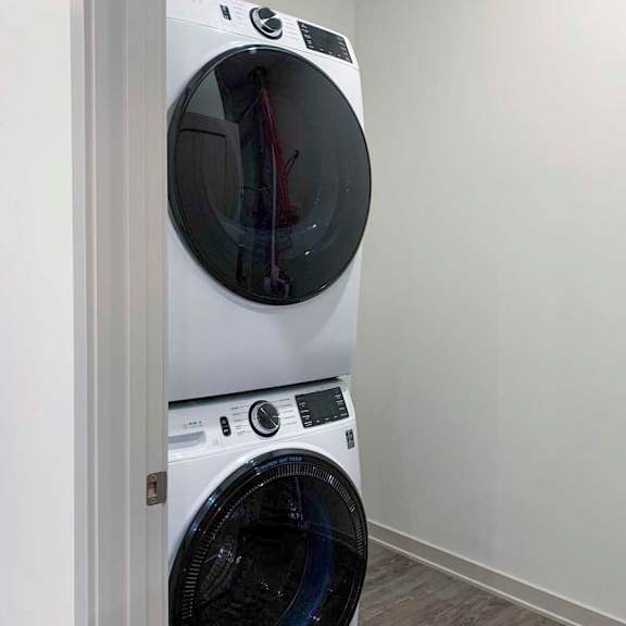 Thumbnail 27 of 29 the in-unit laundry room featuring a full-sized stackable, frontloading washing machine and dryer