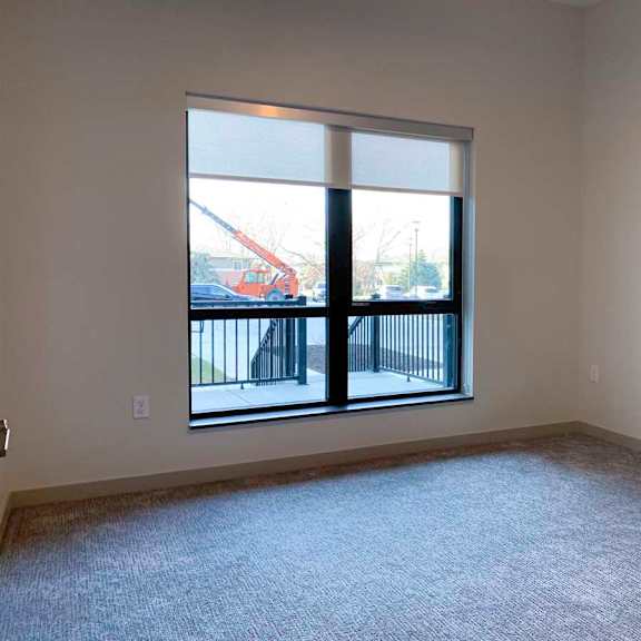 Thumbnail 17 of 29 a bedroom with a large window overlooking a walk-out patio