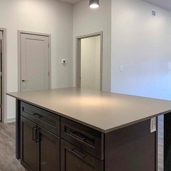 Thumbnail 8 of 29 a kitchen island in front of a laundry room, closet, and den space
