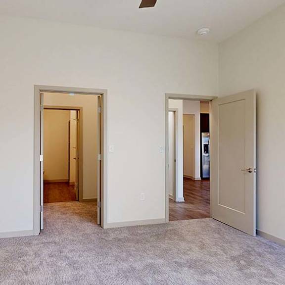 Thumbnail 41 of 50 A room with carpeted floor and three doors.