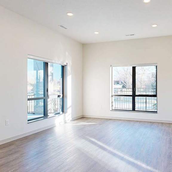 Thumbnail 39 of 50 Open apartment living area with wood-style flooring, large windows, and natural light.