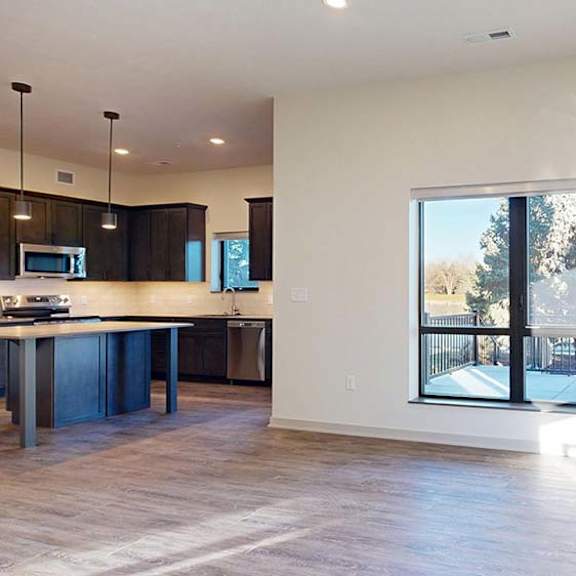 Thumbnail 40 of 50 A modern kitchen with dark wood cabinets and a large window overlooking a patio.