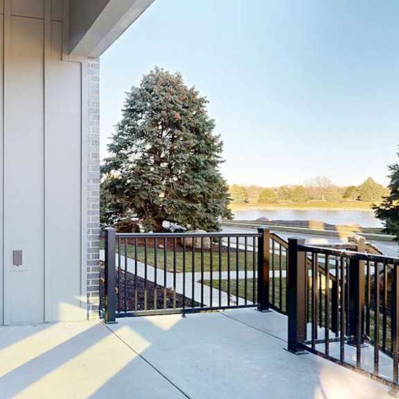 Thumbnail 50 of 50 Covered apartment patio with a private entrance and metal railing.