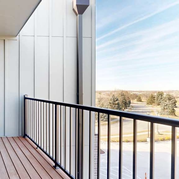 Thumbnail 10 of 21 A balcony with a metal railing and a view of the neighborhood.
