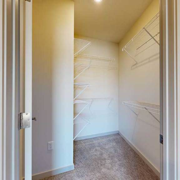 Thumbnail 18 of 21 An L-shaped walk-in closet with several built-in shelves.