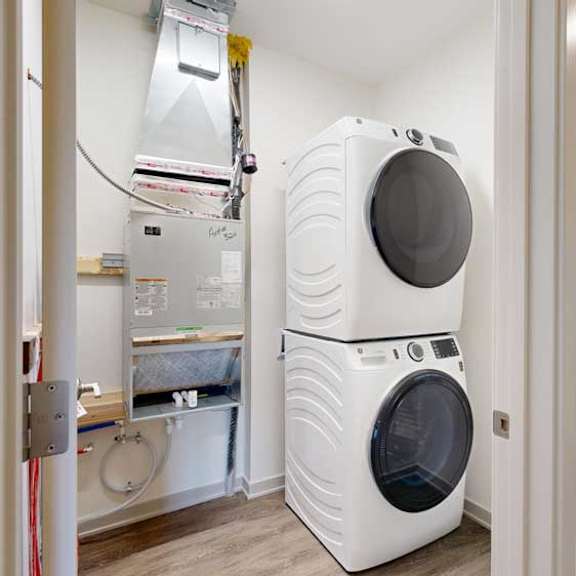 Thumbnail 20 of 21 A stacked full-sized washer and dryer in a laundry room.
