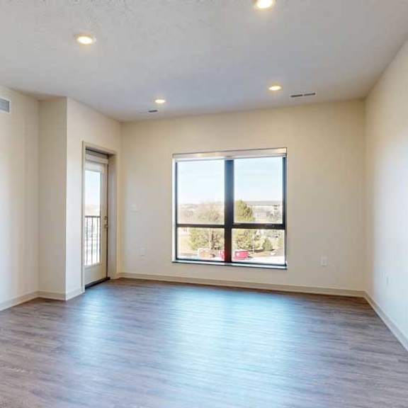 Thumbnail 8 of 21 A living room with hardwood-style flooring and floor-to-ceiling windows.