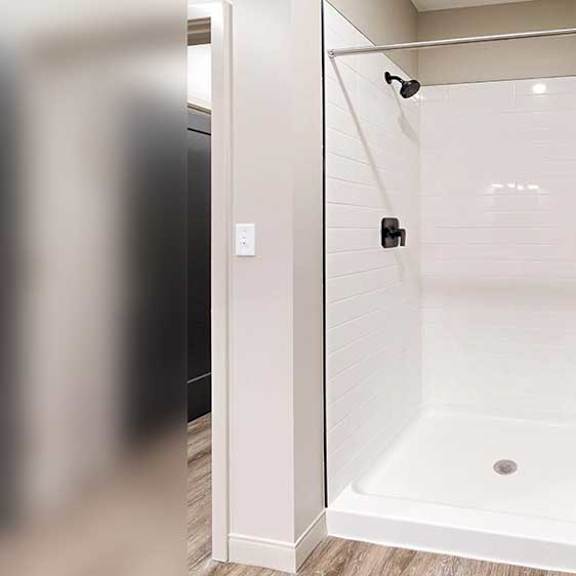 Thumbnail 23 of 26 a white walk-in shower with black finished fixtures