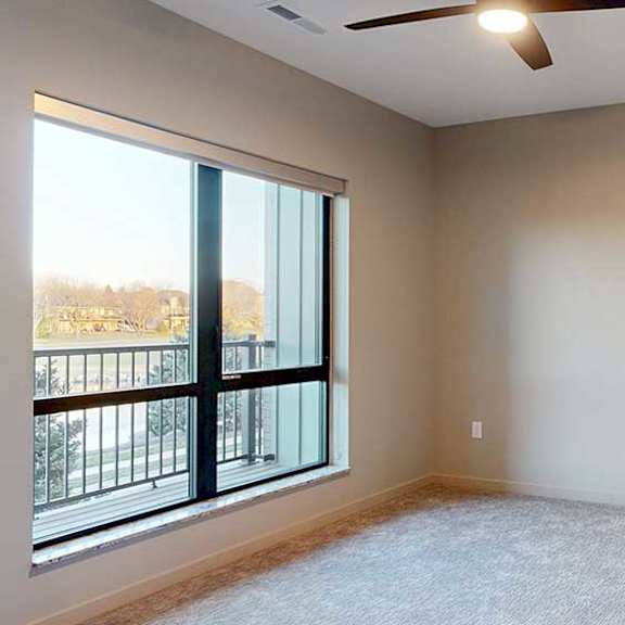 Thumbnail 16 of 26 a bedroom with a ceiling fan and a large window overlooking a balcony