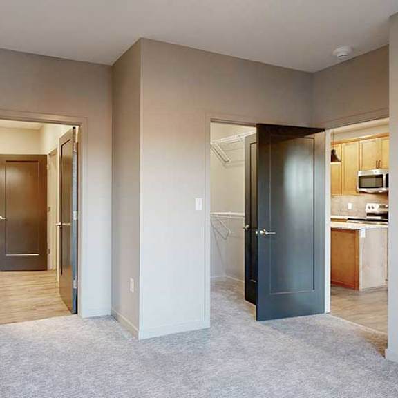 Thumbnail 17 of 26 a bedroom with an attached bathroom, walk-in closet, and door to the living room