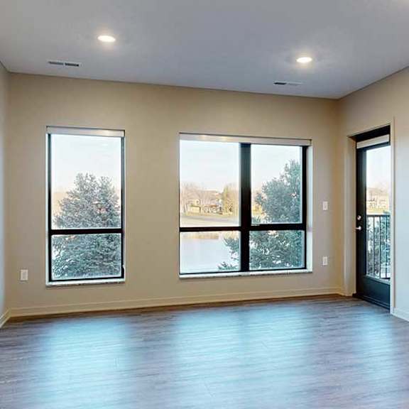 Thumbnail 9 of 26 a living room with two large windows overlooking the pond