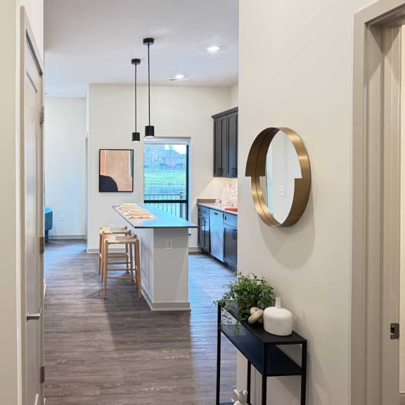 Thumbnail 6 of 20 a view of a spacious kitchen with a micro-island and a dining area from a hallway in the guest suite