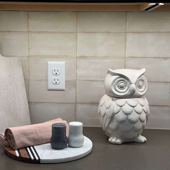 Thumbnail 7 of 20 a kitchen countertop decorated with a wooden cutting board, and owl statue, and a serving tray