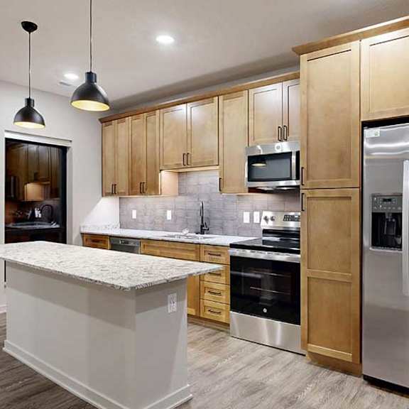 Thumbnail 3 of 20 A modern kitchen with wooden cabinets and stainless steel appliances.