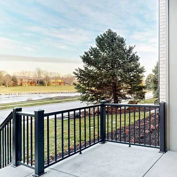 Thumbnail 12 of 22 a balcony facing out toward apartment buildings and green space