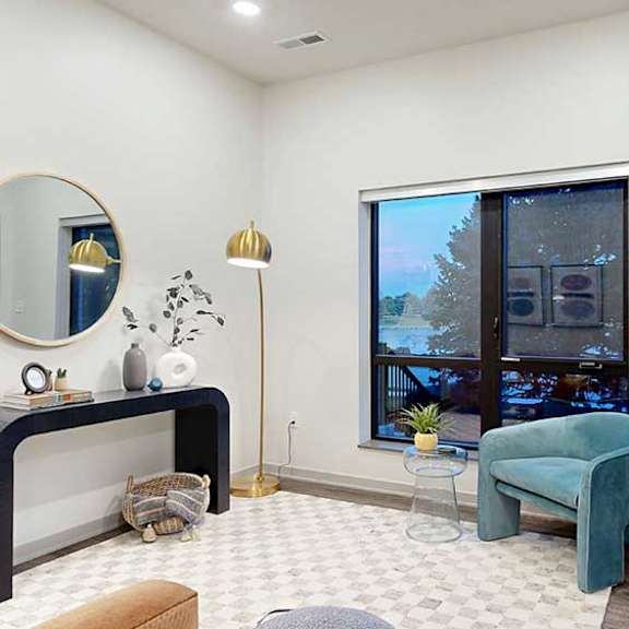 Thumbnail 10 of 22 a studio apartment living area with a chair, small table, and wall-mounted artwork