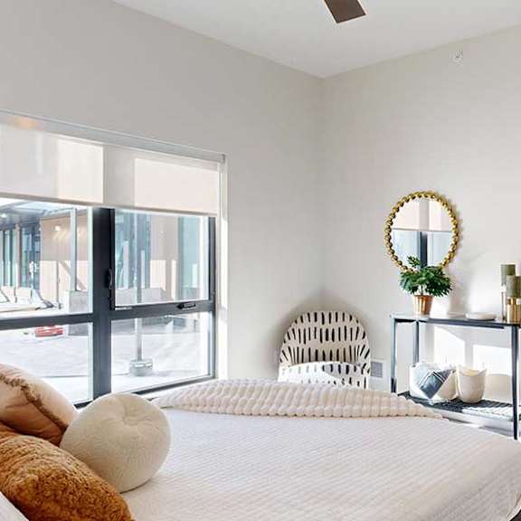 Thumbnail 16 of 23 A furnished bedroom with a floor-to-ceiling window.