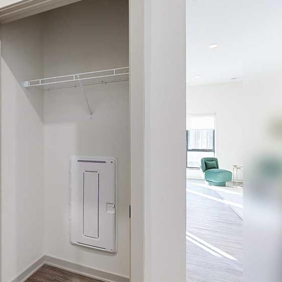 Thumbnail 23 of 23 A hallway coat closet with a wire shelf.