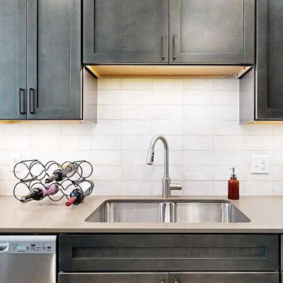 Thumbnail 6 of 26 a modern kitchen with a stainless steel sink, quartz countertops, a light tile backsplash, and dark wooden cabinets