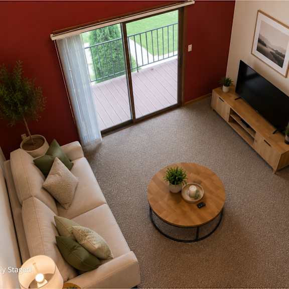 Thumbnail 7 of 11 A living room with a couch, a coffee table, a television, and a staircase.