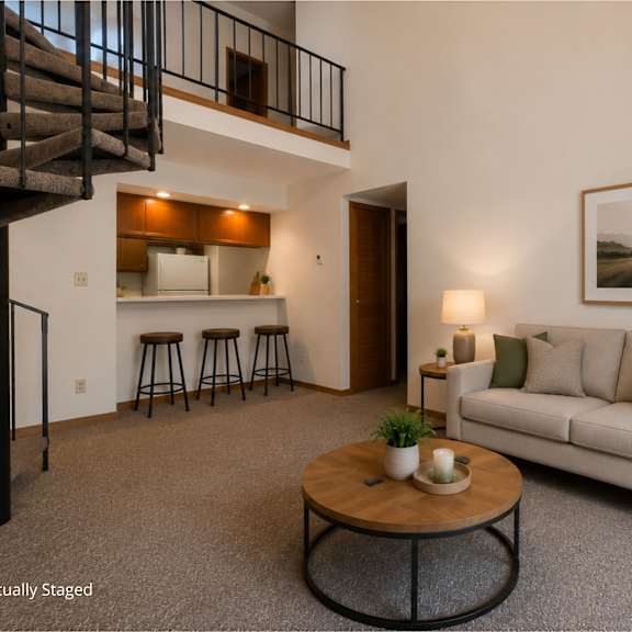 Thumbnail 6 of 11 A living room with a white couch, a coffee table, and a staircase.