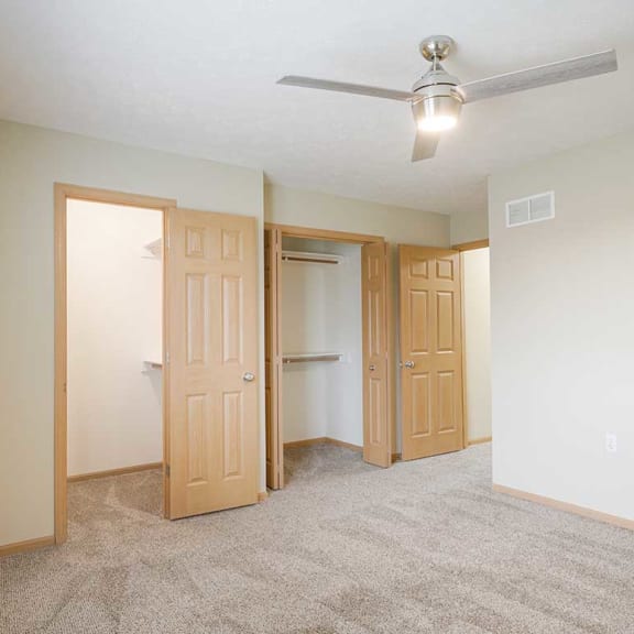 Thumbnail 16 of 26 a bedroom with ceiling fan and two closets