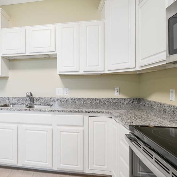 Thumbnail 8 of 26 a kitchen with white cabinets and granite countertops