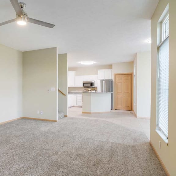 Thumbnail 6 of 26 a living room with a ceiling fan adjacent to a dining room and kitchen